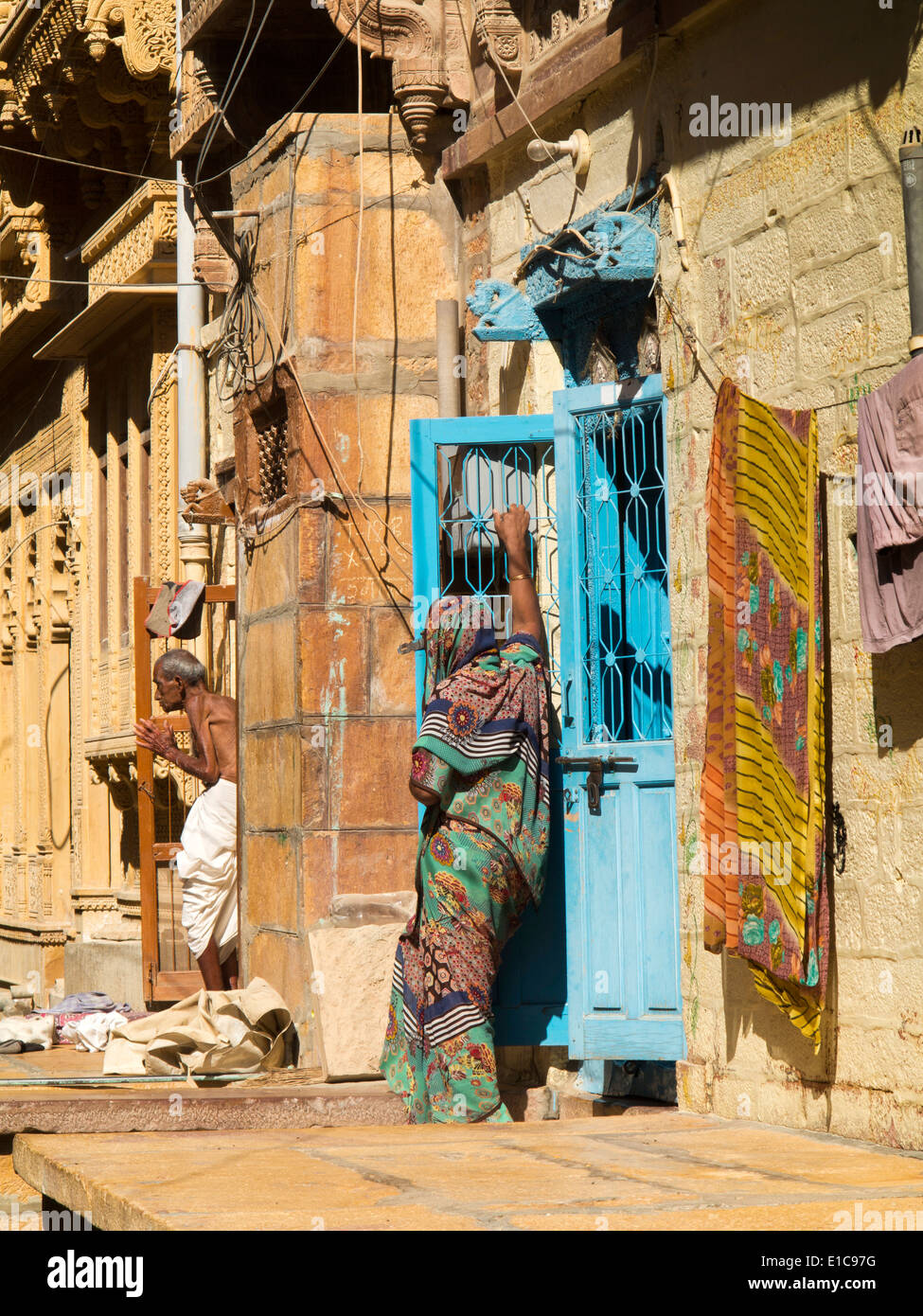 India, Rajasthan, Jaisalmer, residents on roadside terraces of newly restored backstreet houses Stock Photo