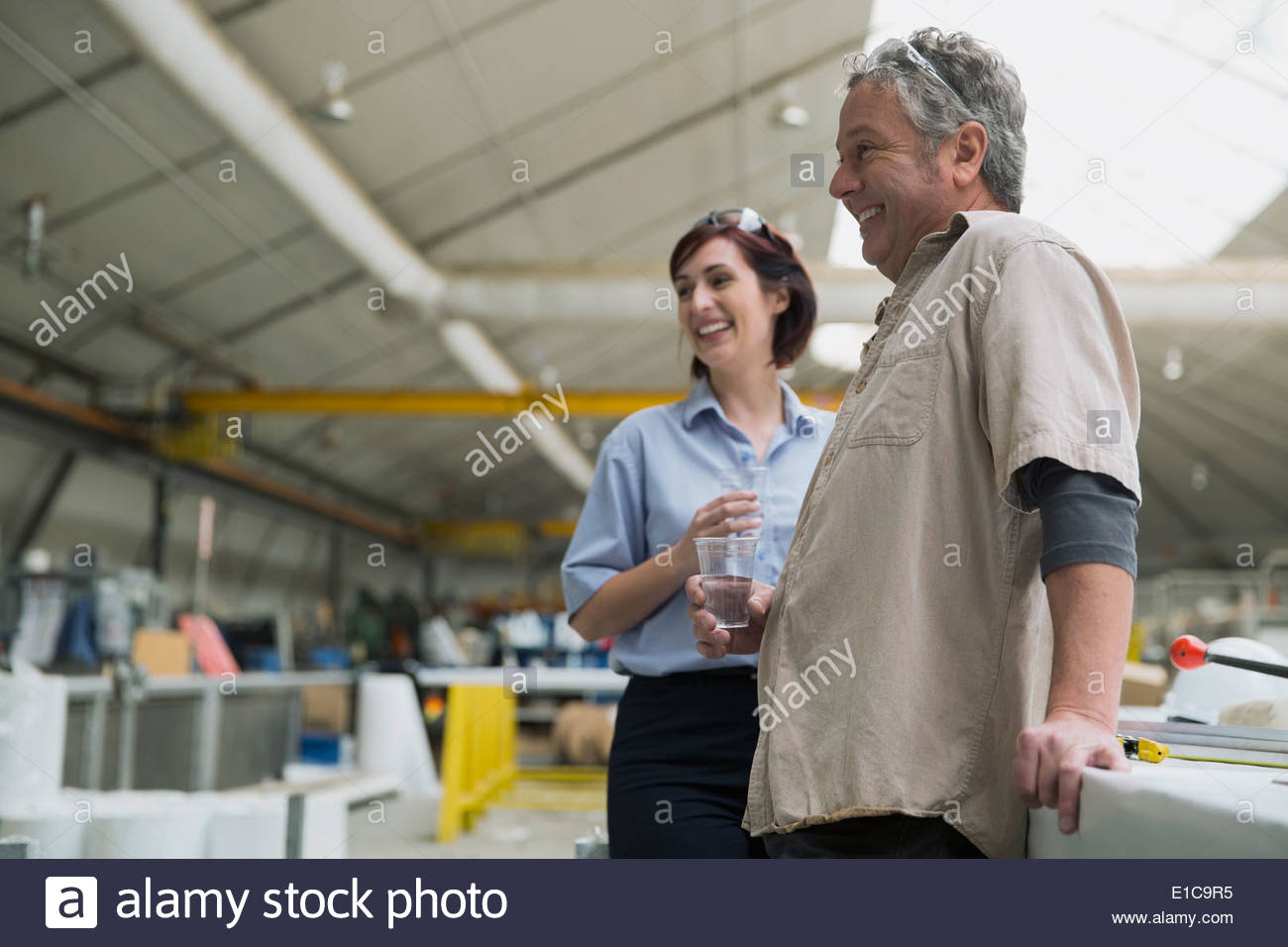 Workers talking in manufacturing plant Stock Photo
