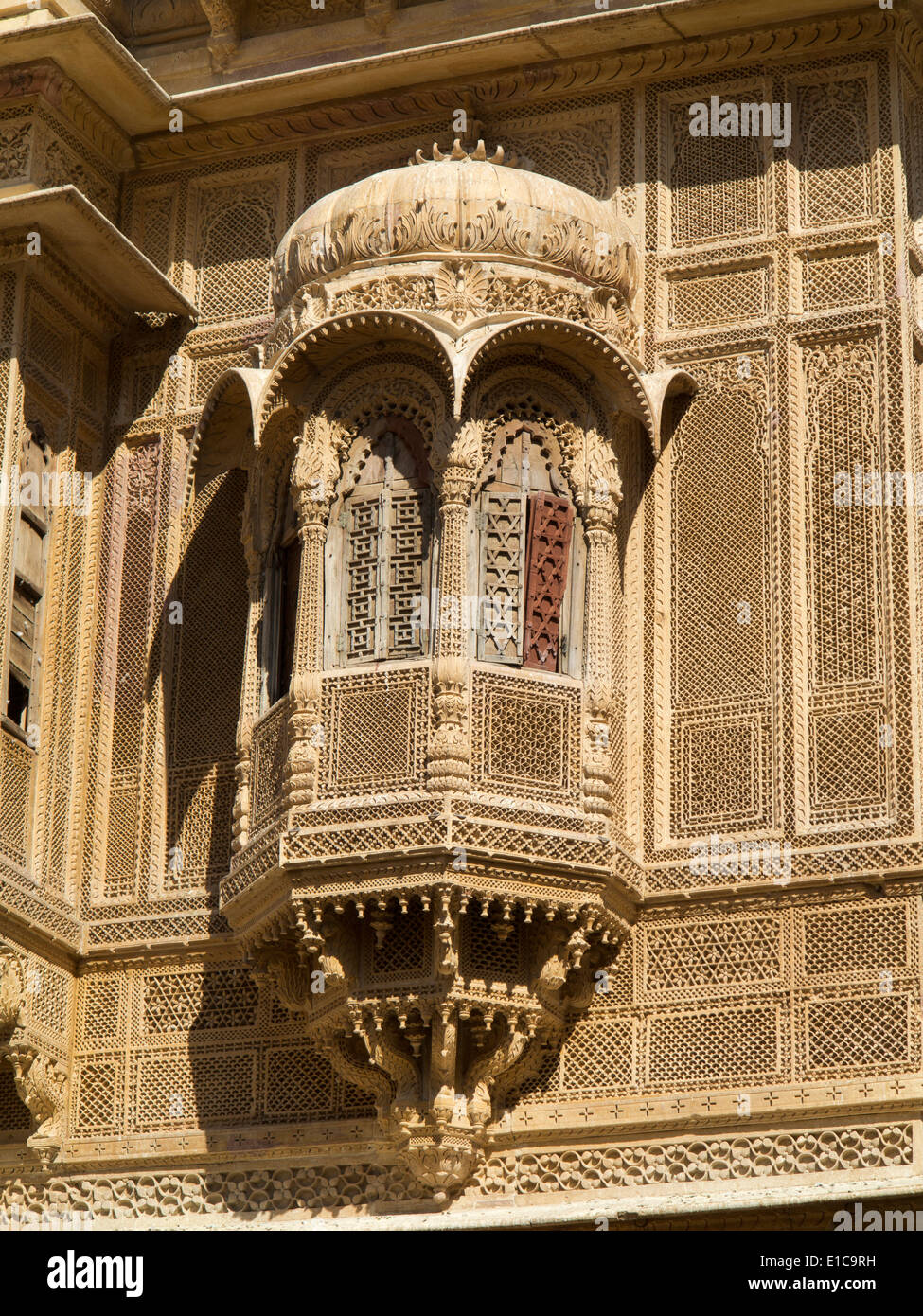 India, Rajasthan, Jaisalmer, Patwon Ki Haveli carved sandstone projecting window balcony with wooden shutters Stock Photo