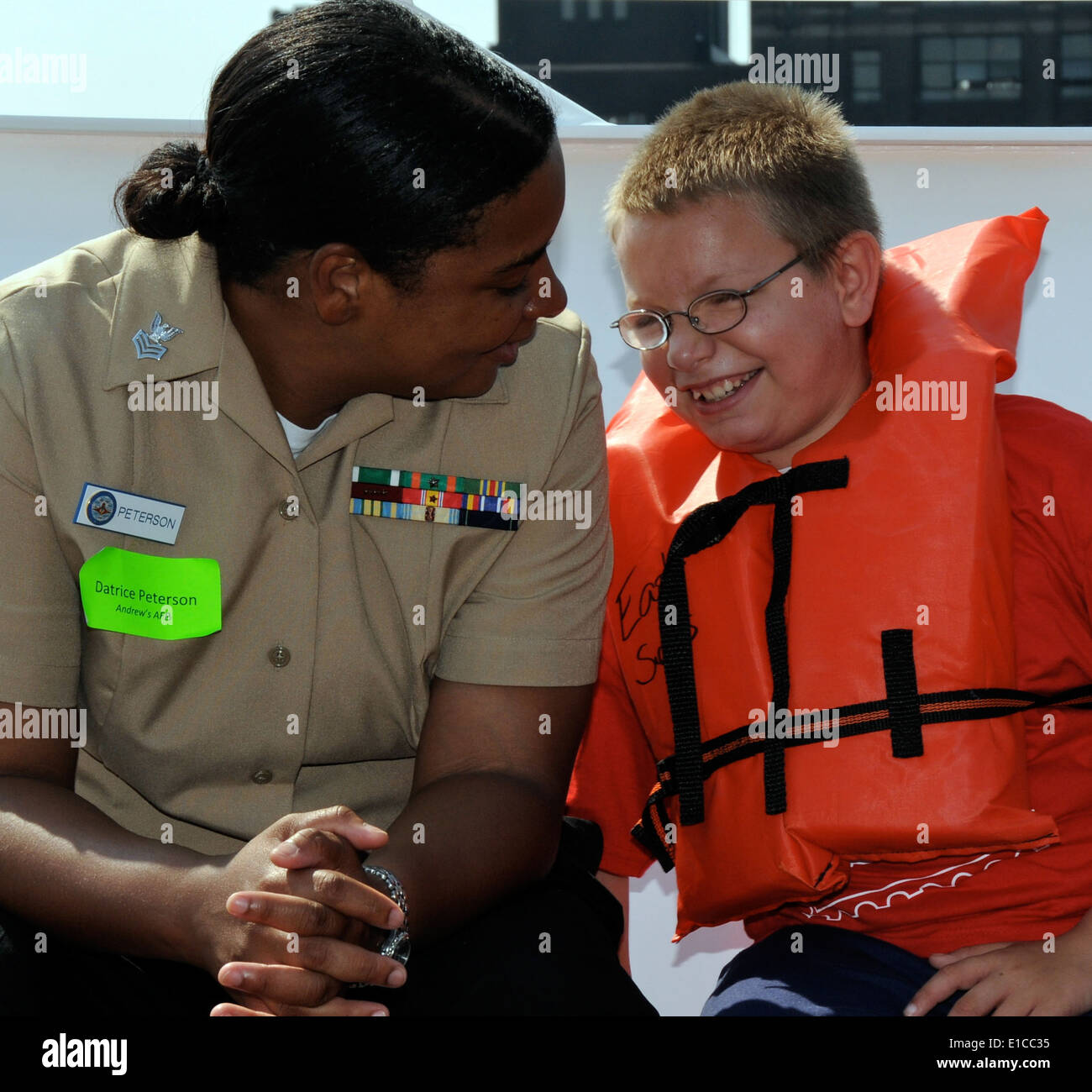 U.S. Navy Yeoman 1st Class Datrice Peterson, assigned to Fleet Readiness Center Mid-Atlantic, chats with a child aboard a yacht Stock Photo