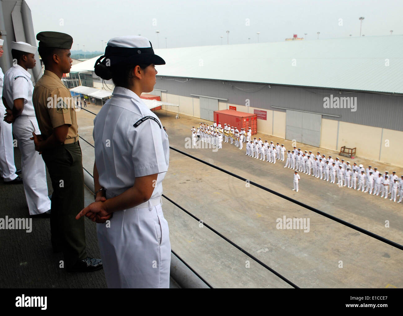 U.S. Sailors and Marines man the rails of the dock landing ship USS Harpers Ferry (LSD 49) as Royal Bruneian Navy sailors stand Stock Photo