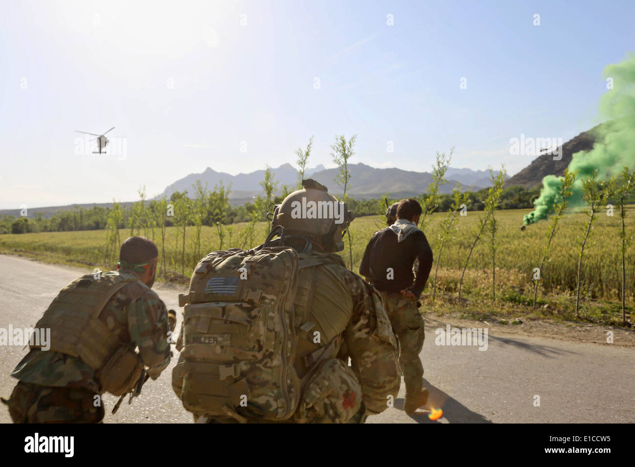 A US Army Special Forces rush an injured Afghan National Army Special Force commando to a helicopter medical evacuation following a firefight with Taliban insurgents May 27, 2014 in the Nejrab district, Kapisa province, Afghanistan. Stock Photo