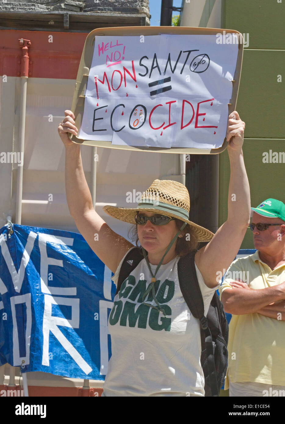 Asheville, North Carolina, USA - May 24, 2014: Woman holds a sign saying 'Hell no! Monsanto = Ecocide' at a GMO protest rally Stock Photo