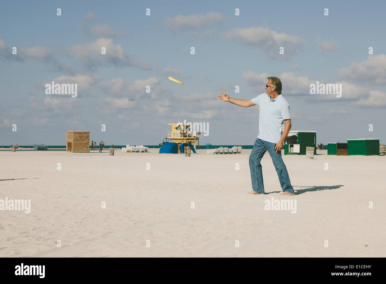 Senior citizens having fun playing frisbee at beach Stock Photo