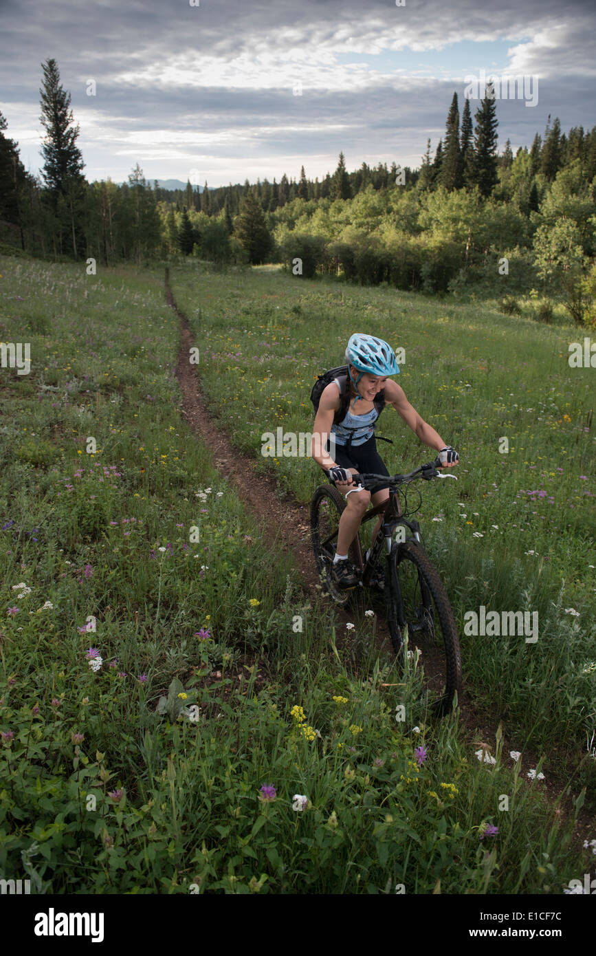 A mountain biker happily rides a single track. Stock Photo