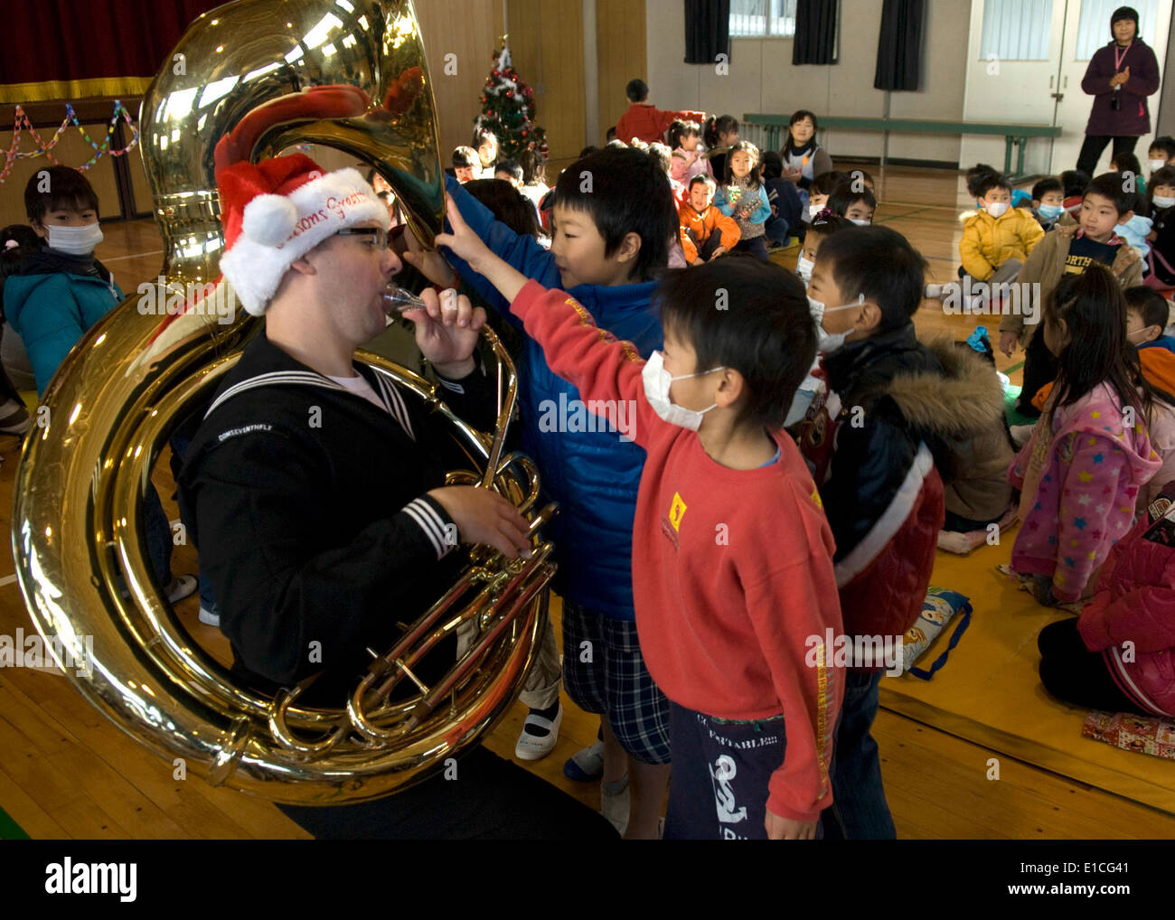 U.S. Navy Musician 2nd Class James Brownell, of the U.S. 7th Fleet brass band, performs for children during a holiday concert a Stock Photo