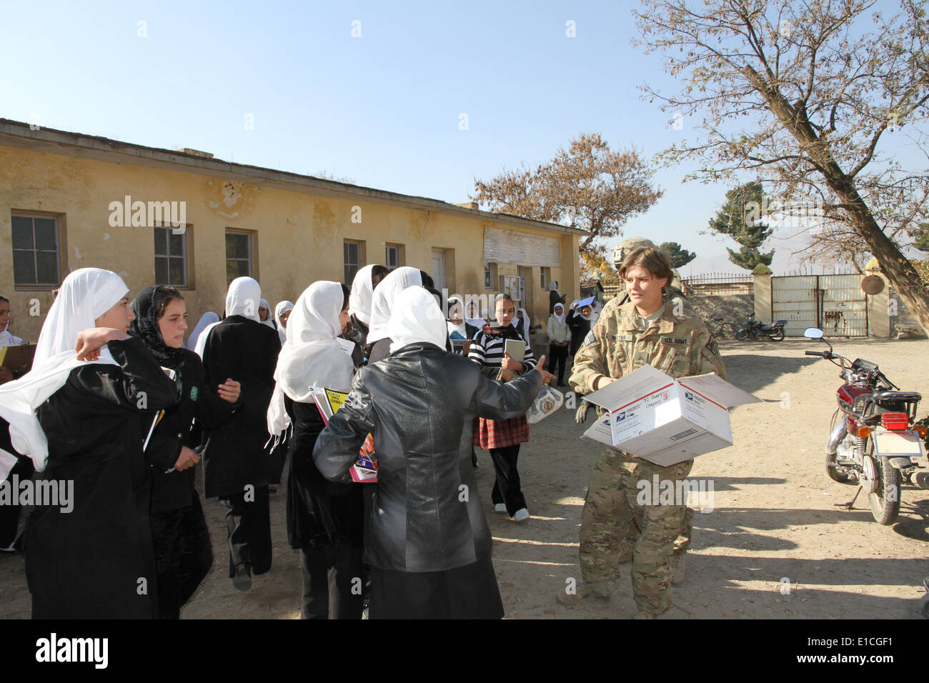 U.S. Army Sgt. Claudia Rector from the Kentucky Army National Guard hands out extra school supplies to children in the 6th grad Stock Photo