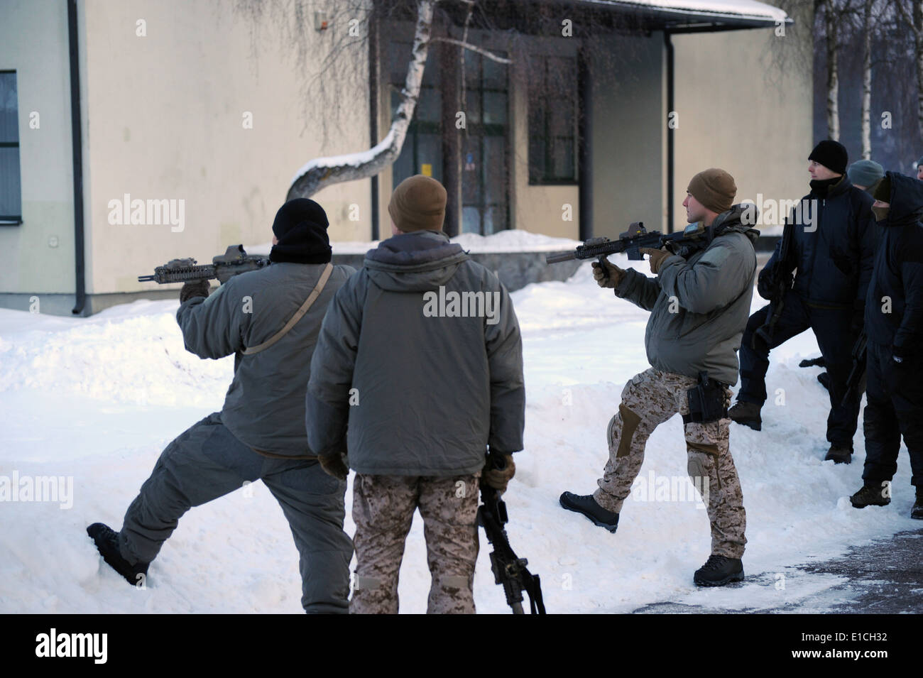 Two U.S. Navy SEALs pull security as another talks to a group during a demonstration for Lithuanian and Latvian special operati Stock Photo
