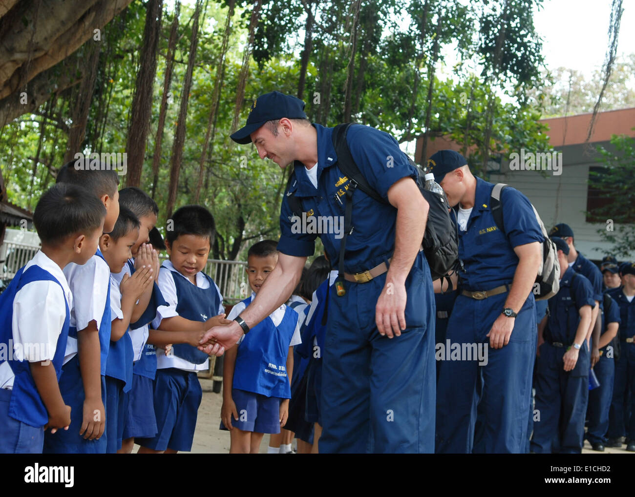 U.S. Sailors assigned to the amphibious dock landing ship USS Harpers Ferry (LSD 49) greet schoolchildren at the Bann Yai Ra Ch Stock Photo