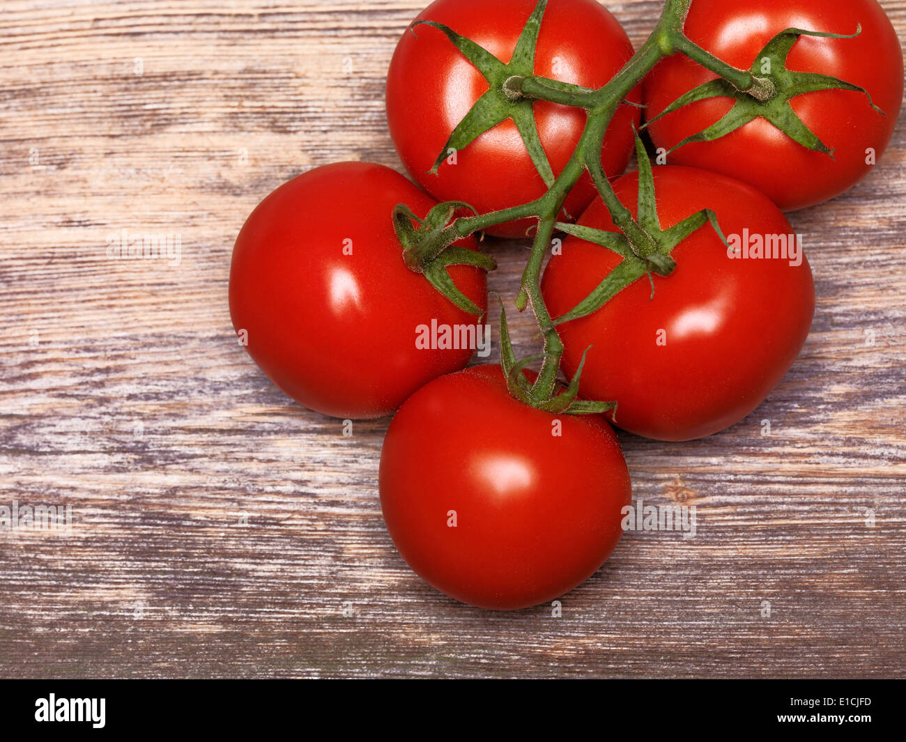Red tomatoes on rustic wooden background Stock Photo