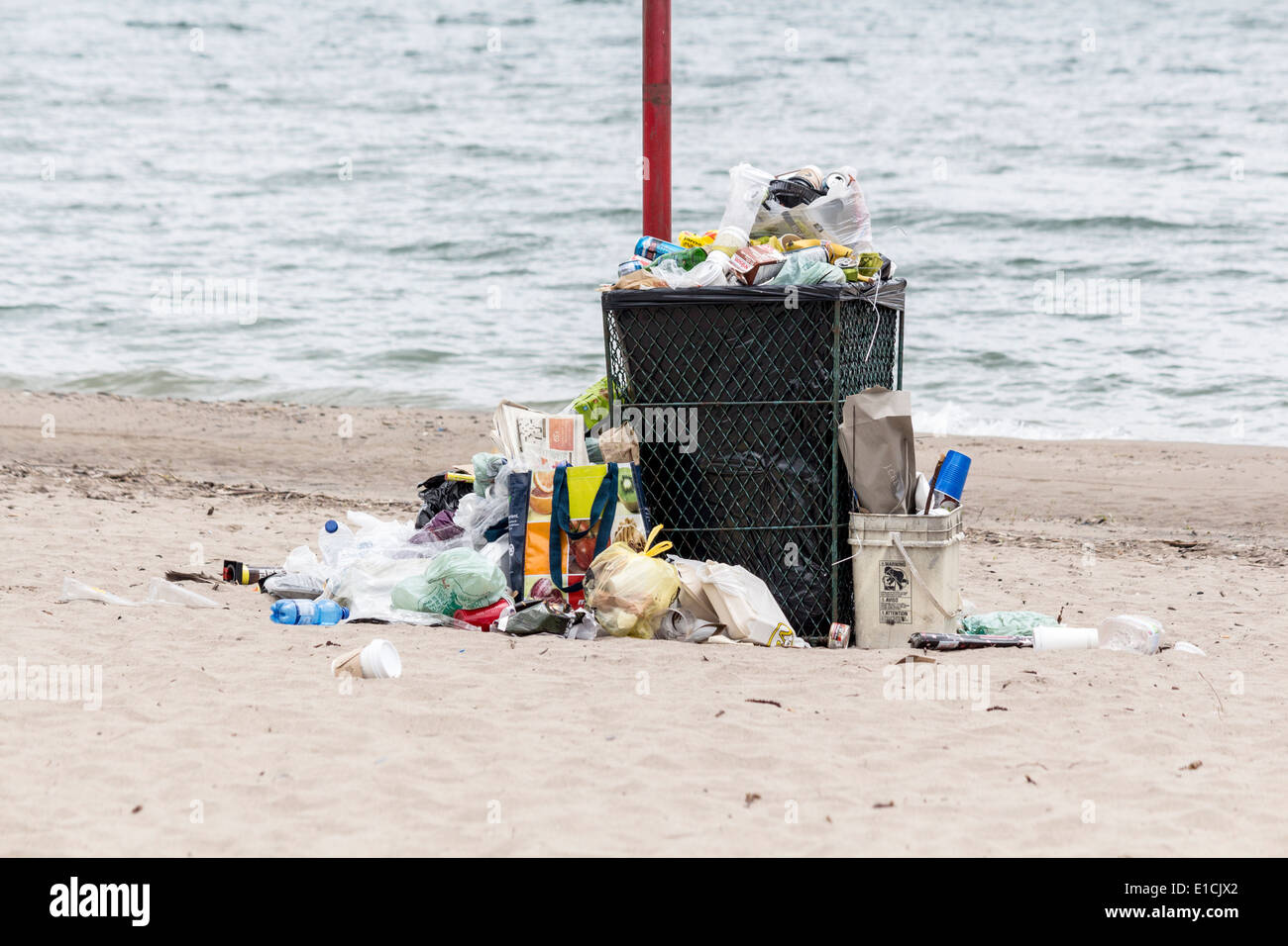 Overflowing garbage can on beach on Ward's Island on Toronto Islands ...