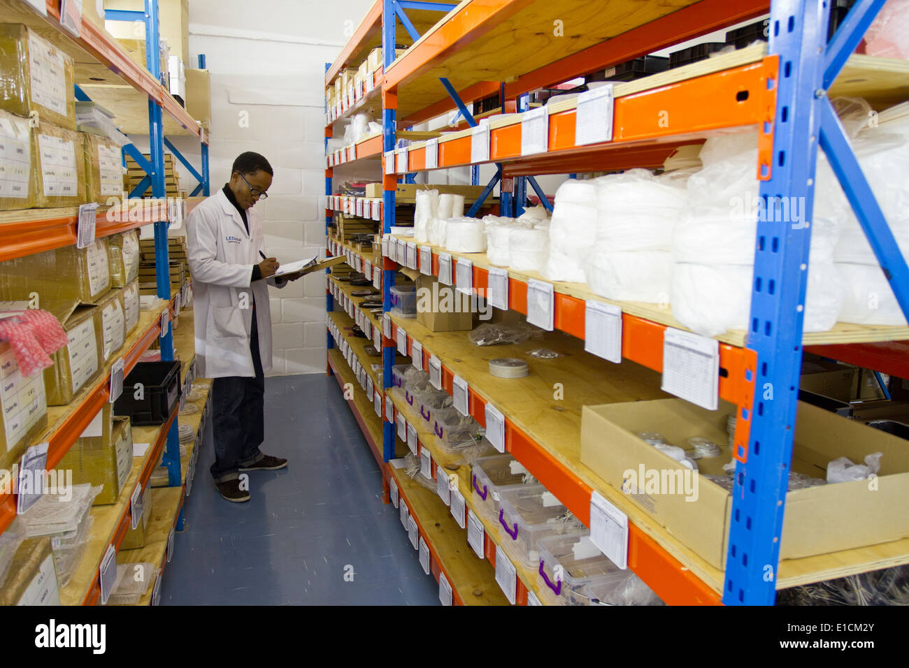 A South African employee taking stock of inventory among rows of shelves in a warehouse Stock