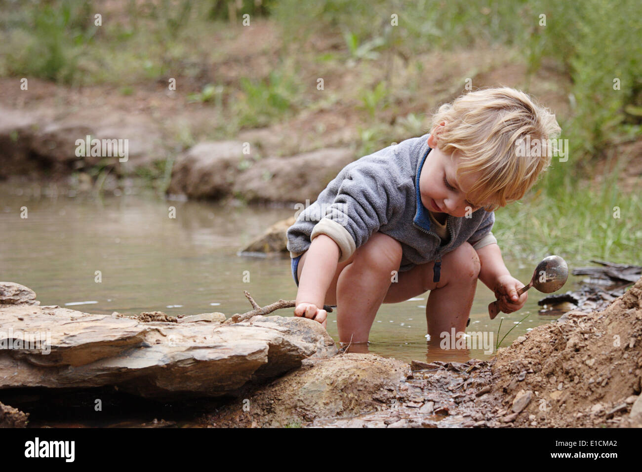 Search Under Rocks Young boy looking for frogs under rocks Stock Photo - Alamy