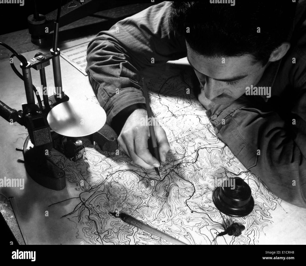 World War 2 Strategic planning for the invasion of Europe. U.S. Army map maker inking in the pencil tracings of culture, Stock Photo
