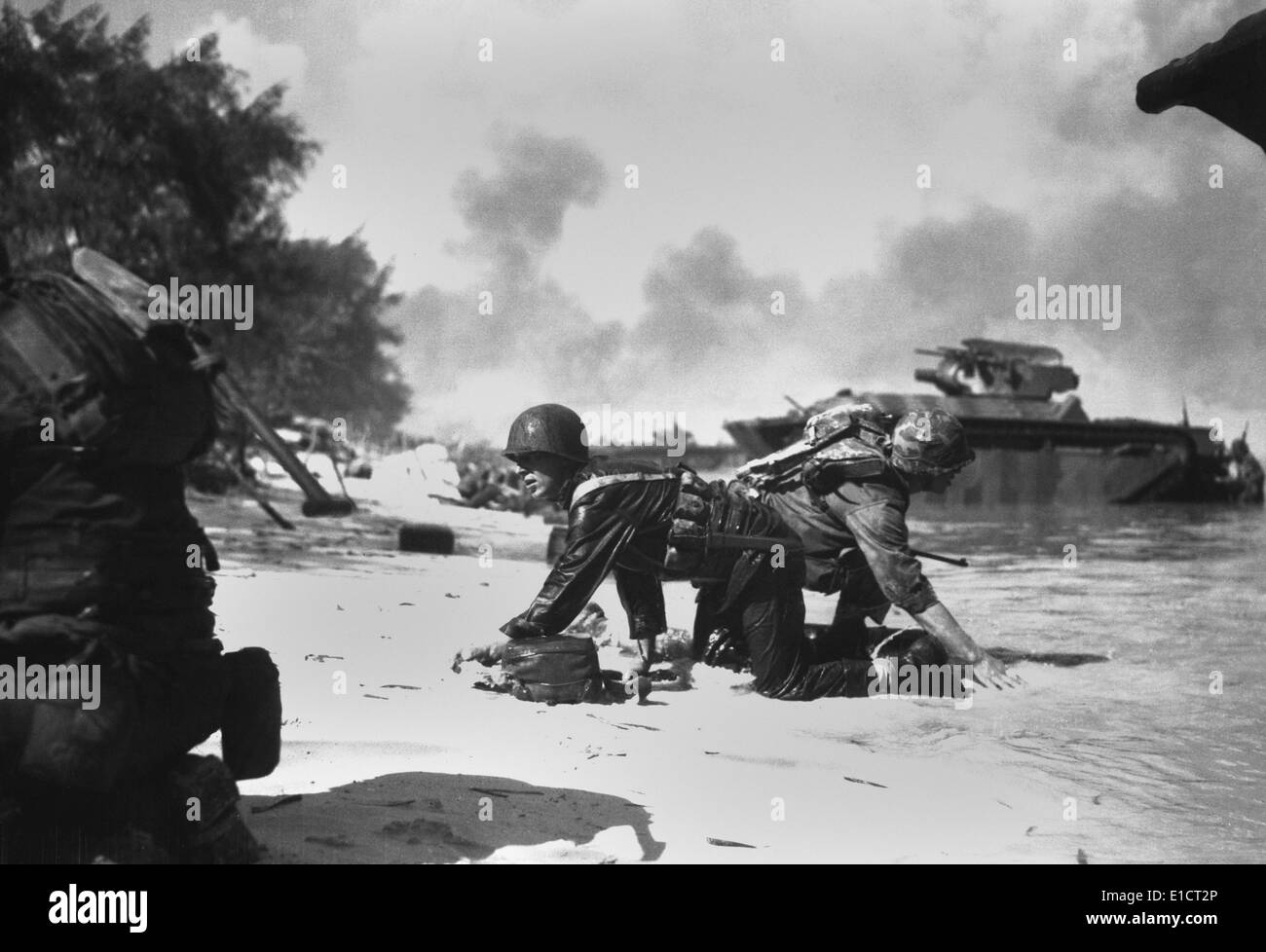 On Saipan, invading Marines under Japanese fire crawl to their assigned positions, June 1944. Many Marines landed on the wrong Stock Photo