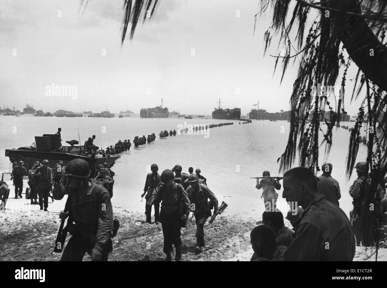 Army reinforcements wade ashore on Saipan without enemy opposition. They will relieve Marines in the battle of attrition raging Stock Photo