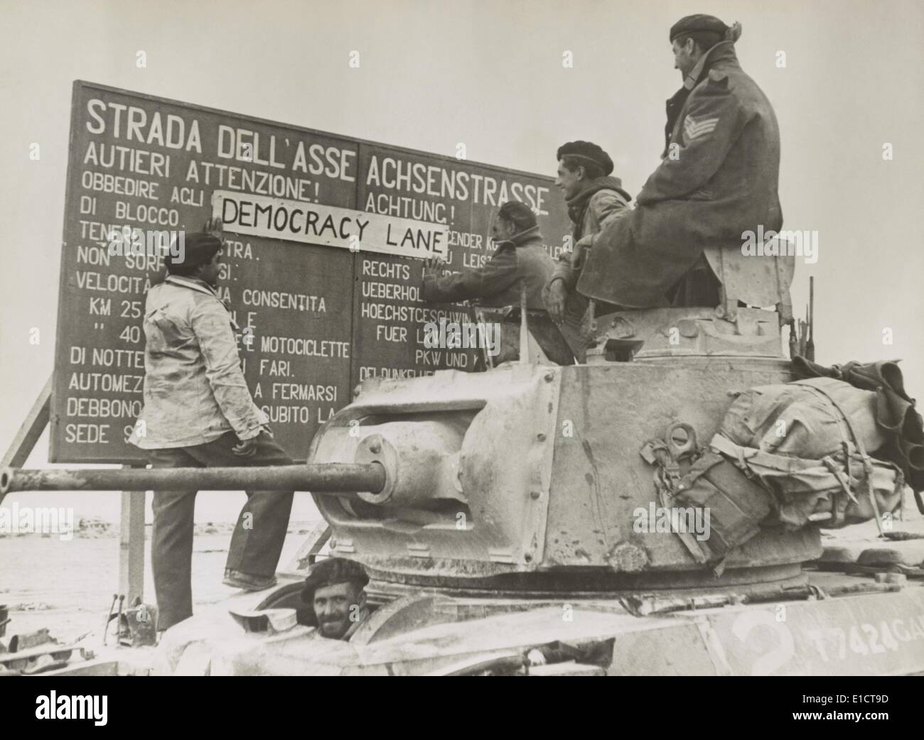 After the British victory at El Alamein, a British tank crew alters an Italian-German language sign. The 'Axis Highway' (Strada Stock Photo