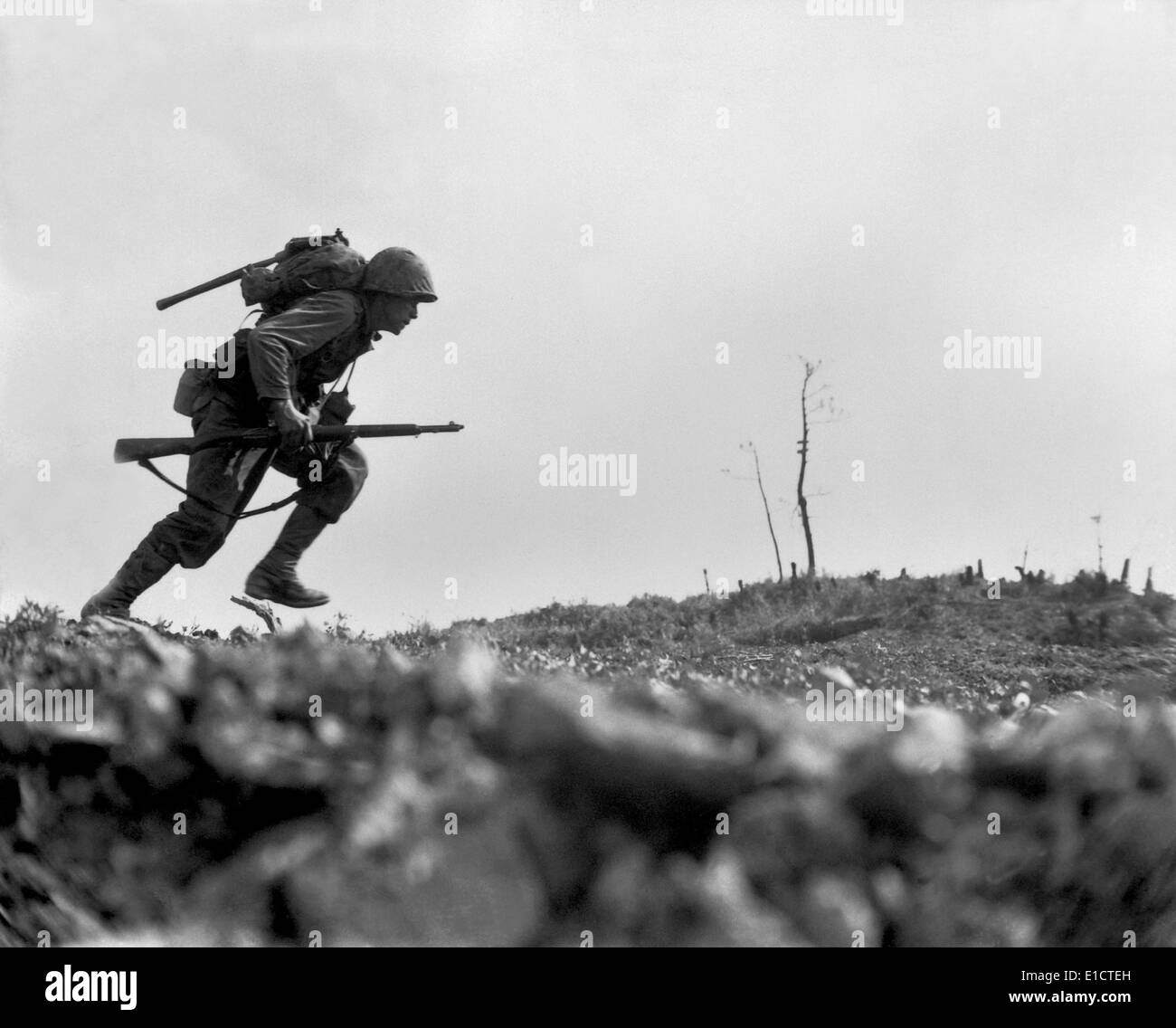 Marine Pfc. Paul E. Ison runs through Japanese machine gun fire on Okinawa, May 10, 1945. He was the first of his unit to cross Stock Photo