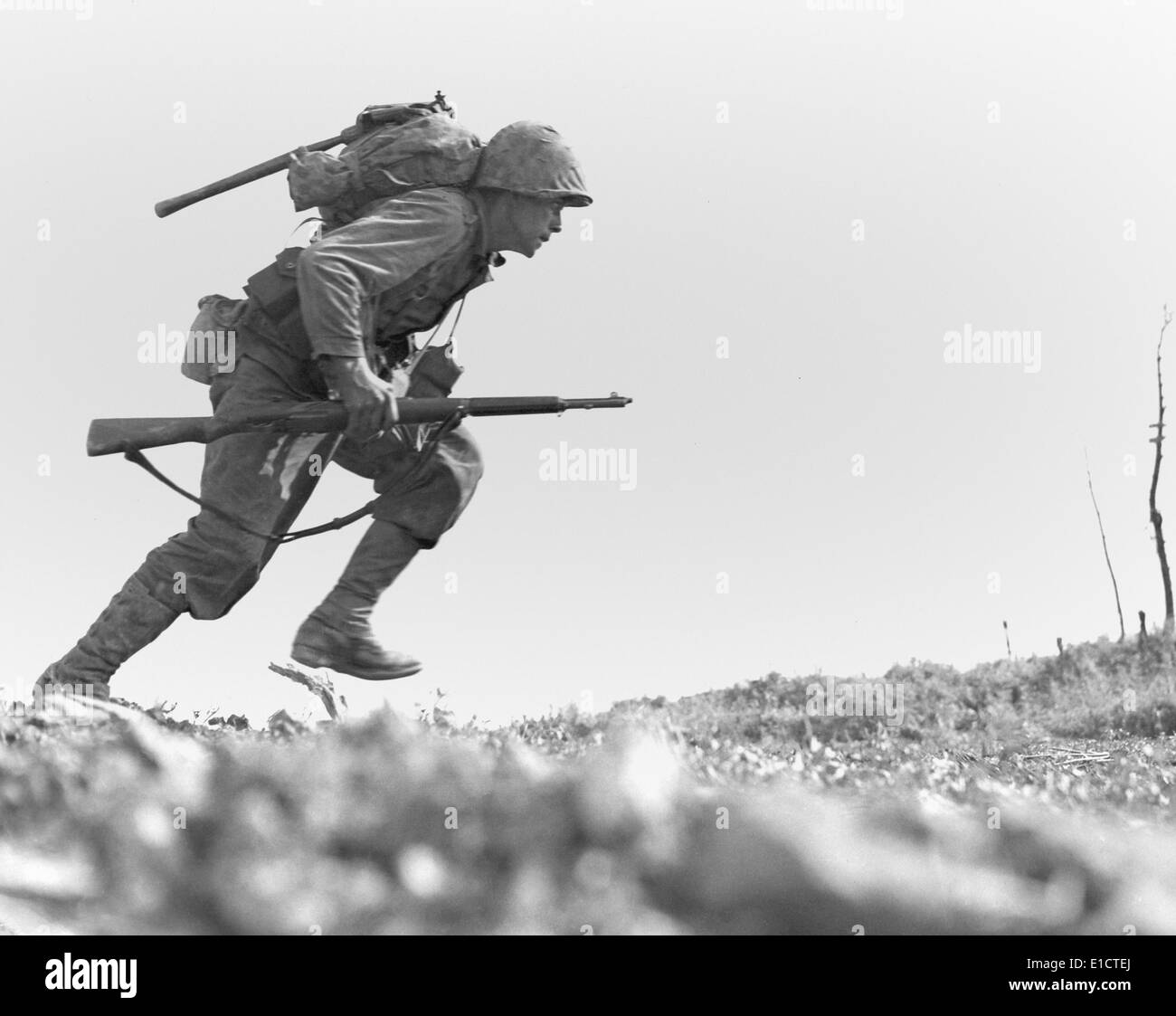 Marine Pfc. Paul E. Ison runs through Japanese machine gun fire on Okinawa, May 10, 1945. Ison and the rest of his unit made Stock Photo