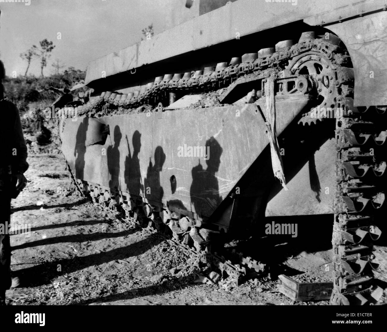 Shadows of 6th Division Marines on a battle-wrecked tank on Okinawa. The soldiers are advancing to mop up operations in the Stock Photo