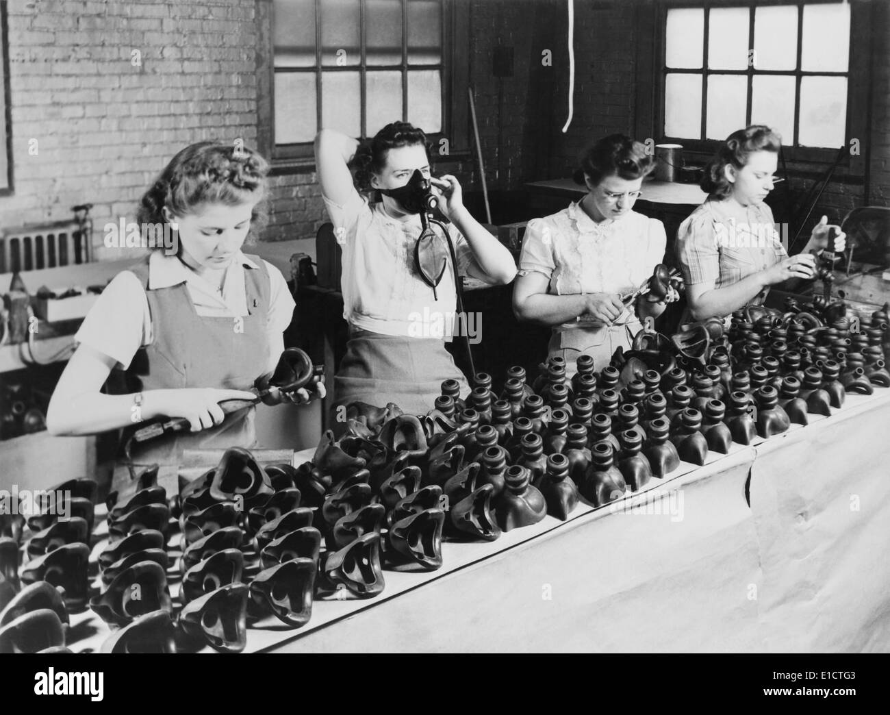 Woman war workers assembling oxygen masks at American Anode Company, in Akron, Ohio. During World War 2, ca. 1942-45. Stock Photo