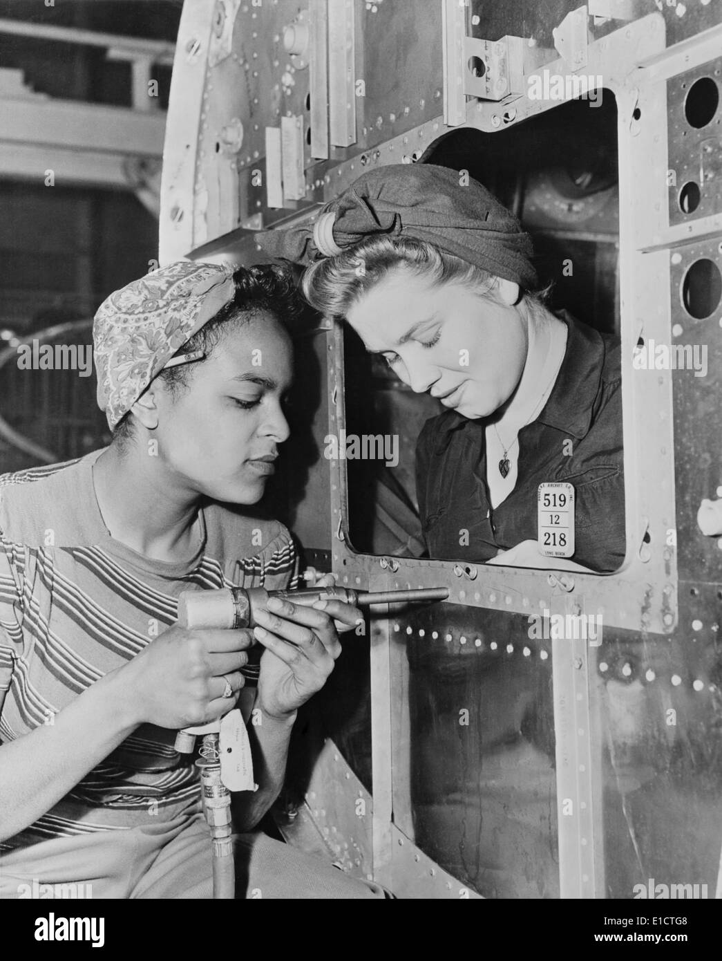 African American woman war worker with her white co-worker. Long Beach Plant of Douglas Aircraft Company had an racially Stock Photo