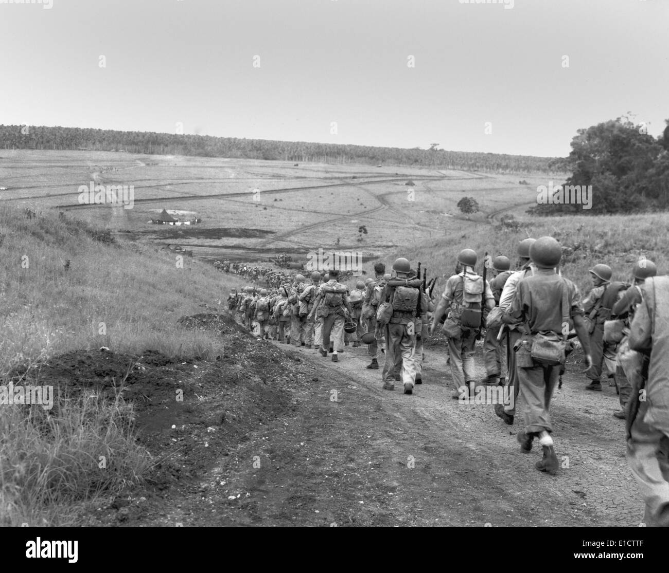 U.S. Marines tired and weary from continuous fighting, march to the U.S. held valley on Guadalcanal. Jan. 1943, during World Stock Photo
