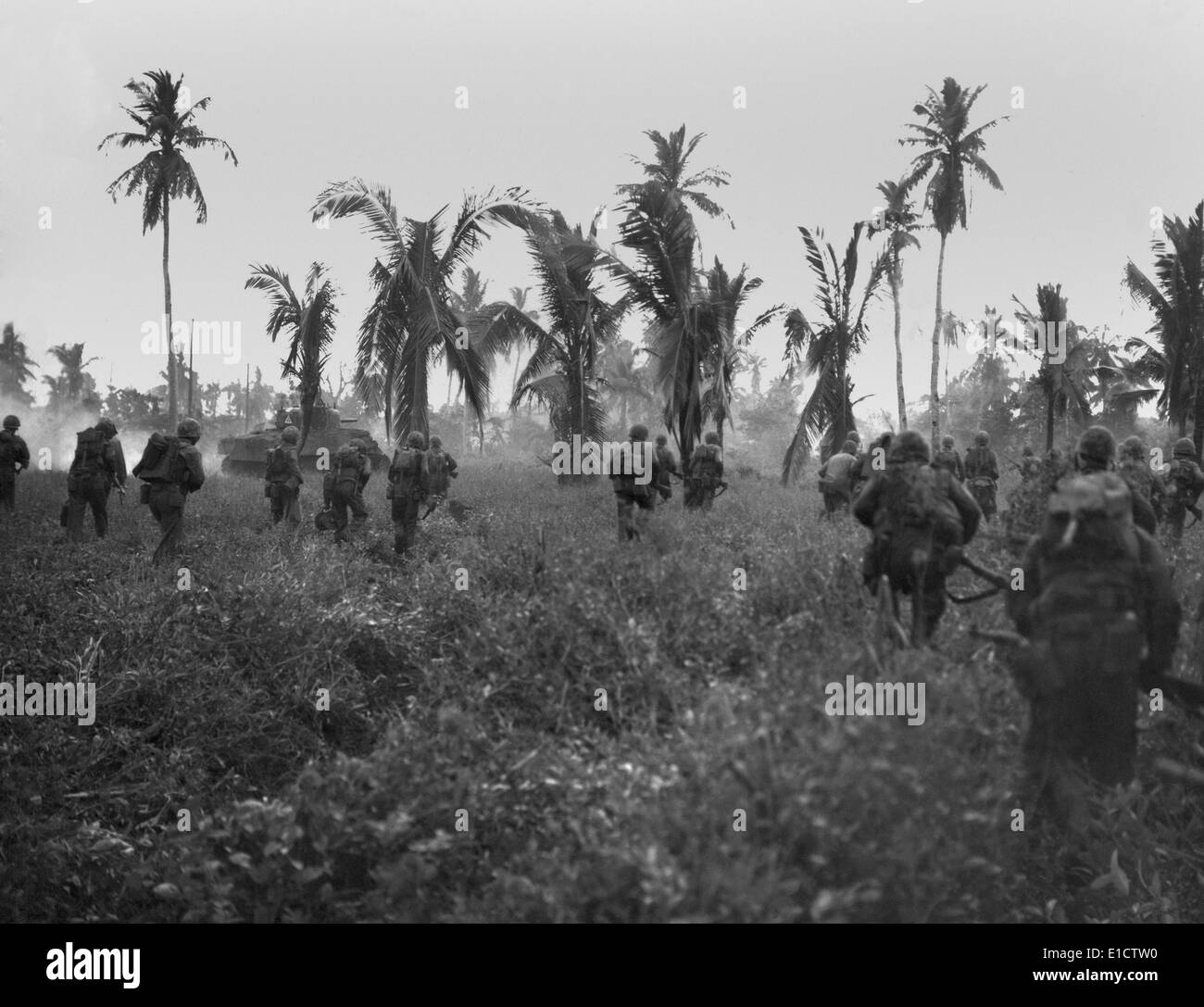 U.S. Marines in pursuit of retreating Japanese on Guam Island. Sherman tanks lead the assault through thick brush. July 1944, Stock Photo