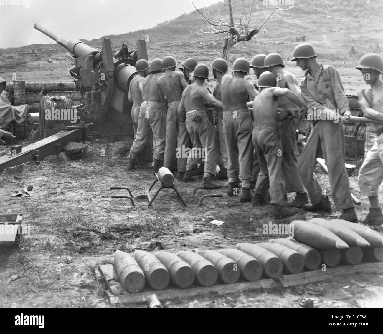 U.S. Marines cleaning artillery on Guam Island. Gunners swab the bore of their gun during a lull in fighting against the Stock Photo