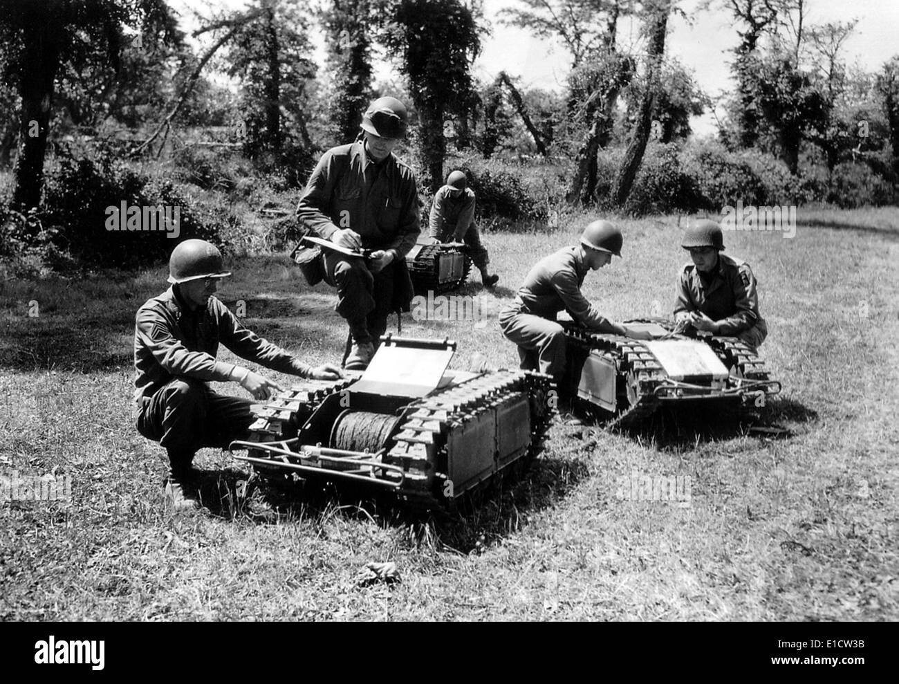 U.S. soldiers inspect German tactical mini-tracked vehicles. The robots carried bombs toward invading Allied troops on D-Day Stock Photo