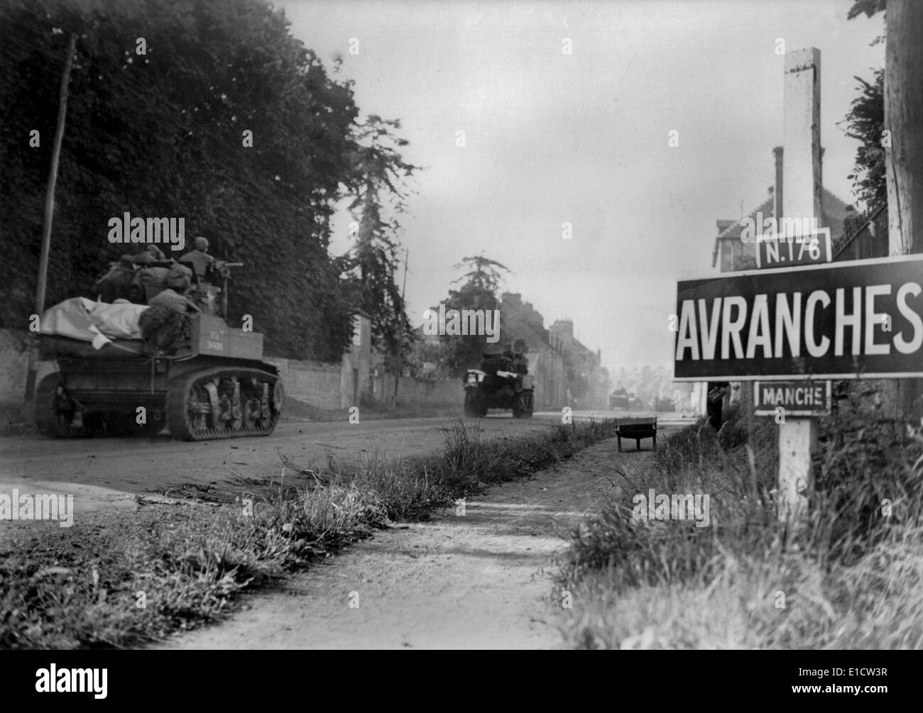 U.S. light tanks passing a road sign for the town of Avranches, southeast of the Falaise Pocket. In the early days of Operation Stock Photo