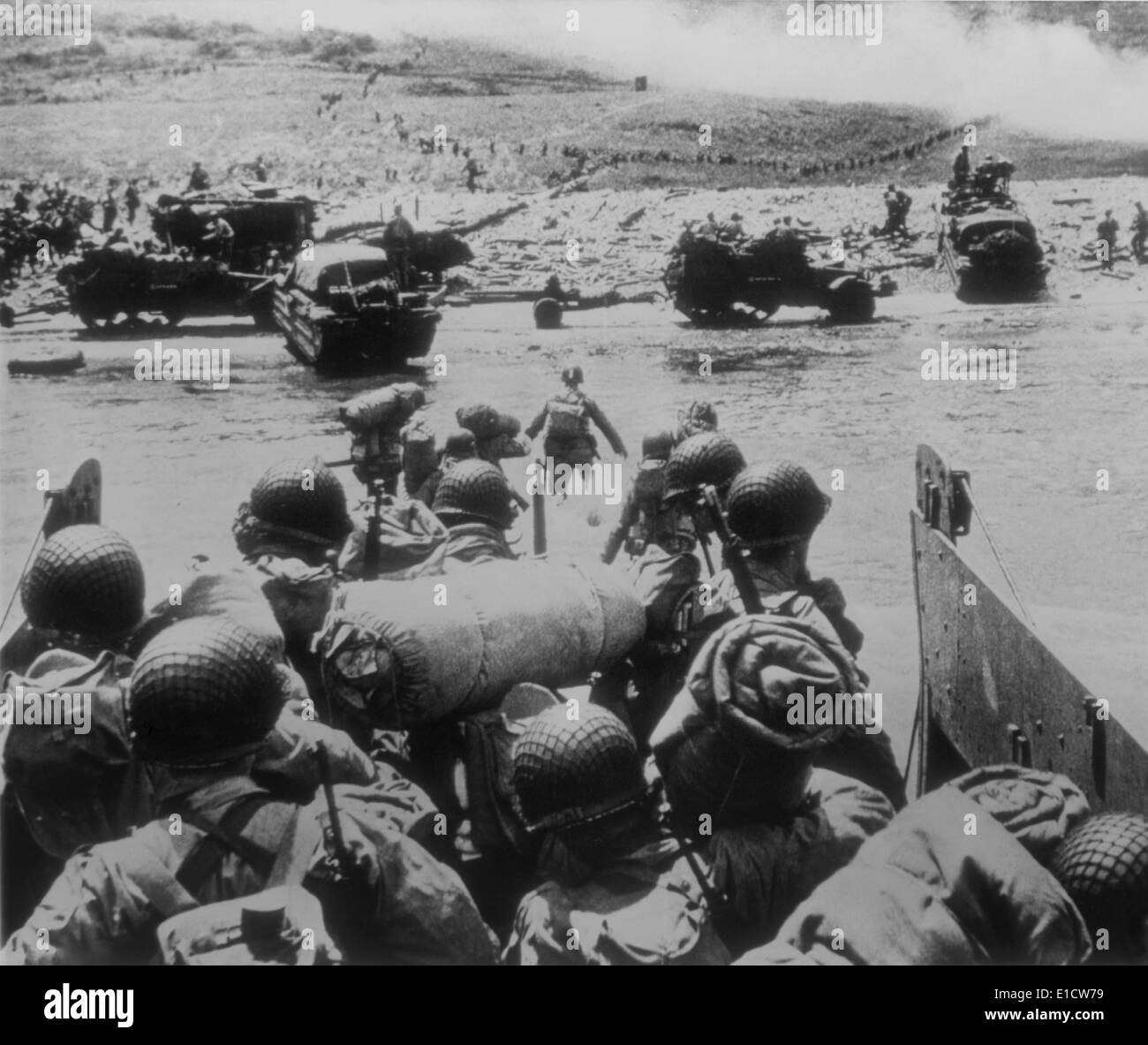 U.S. soldiers landing on Utah Beach, the westernmost landing of the D-Day invasions. In the distance soldiers move inland, as Stock Photo