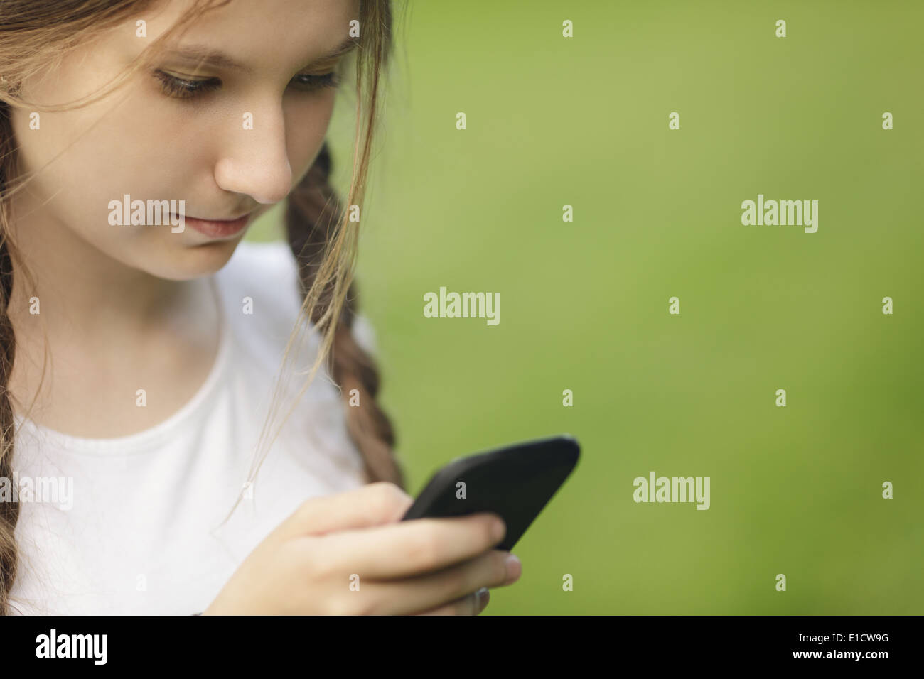 teen girl using mobile phone outdoors in park Stock Photo - Alamy