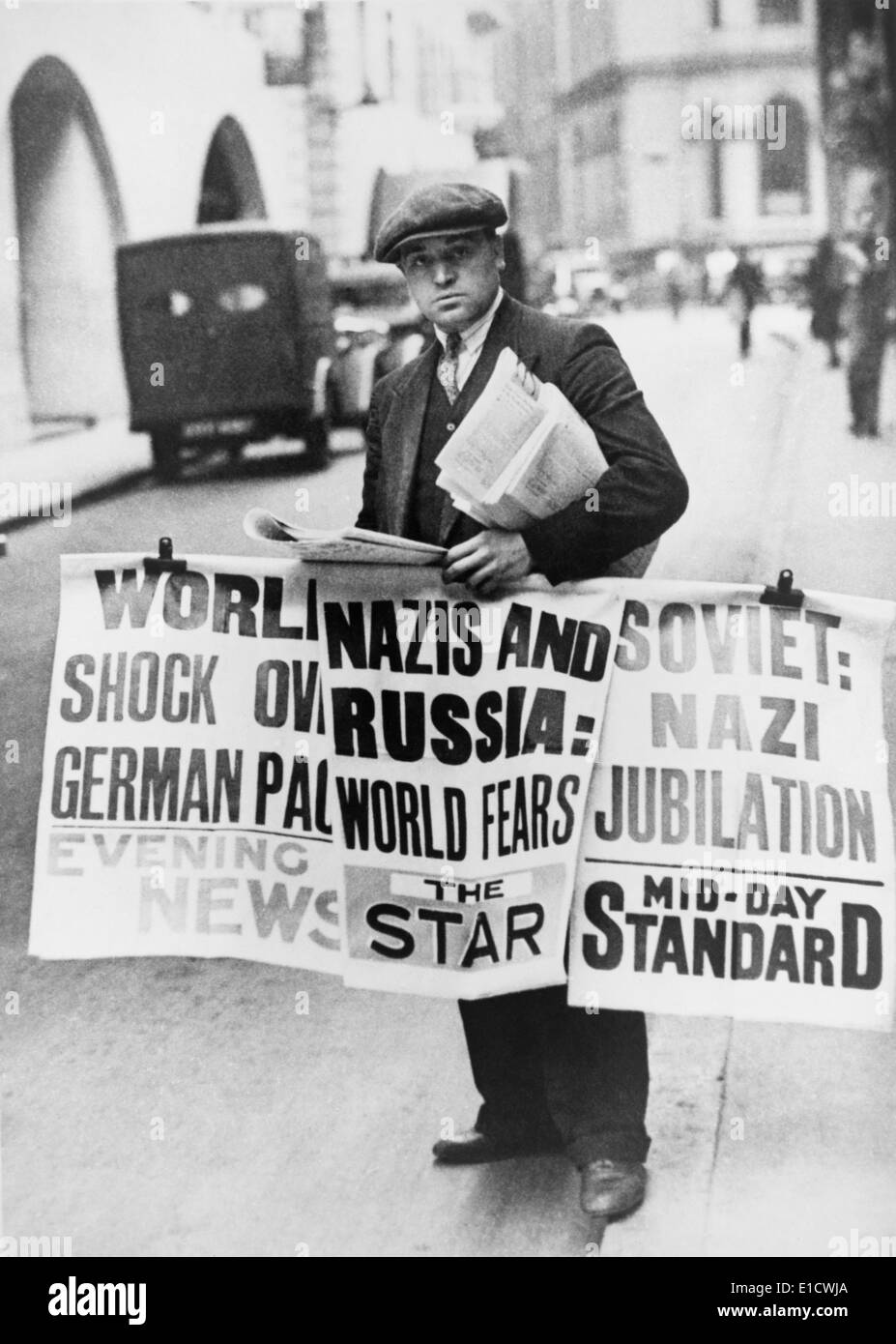 British man holding newspapers and large signs announcing Nazi German- Soviet Russian non-aggression pact. London, England. Stock Photo