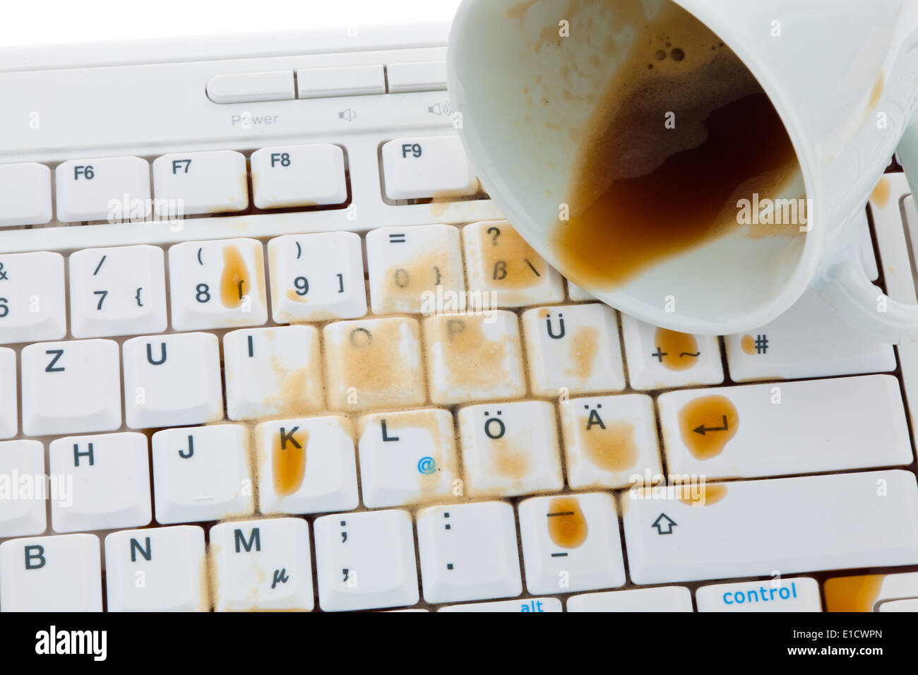 Cup of coffee spilled on a computer keyboard. Damage insurance. Stock Photo