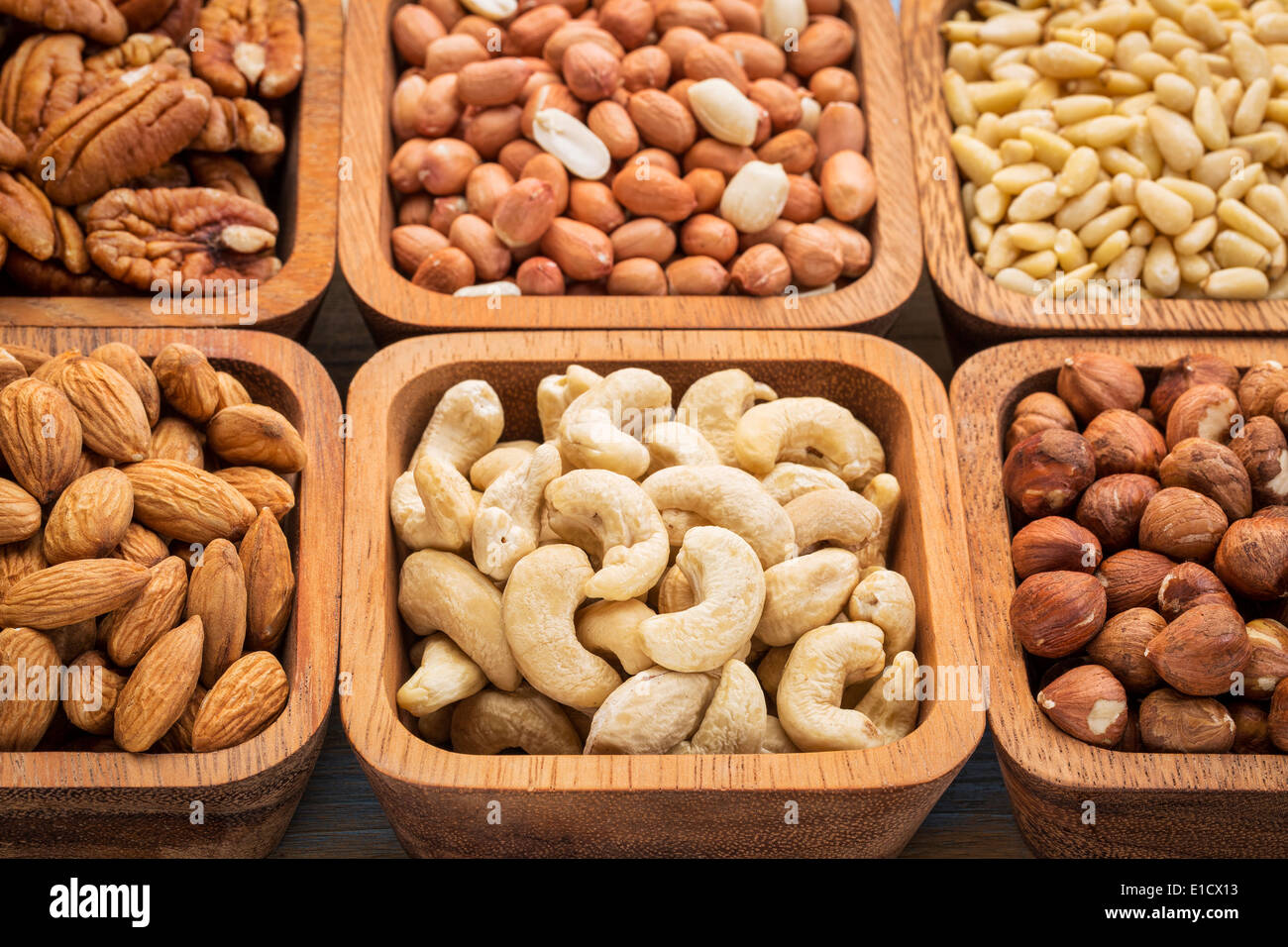 nuts abstract - cashew, pecan, hazelnut, Spanish peanut in wooden bowls Stock Photo