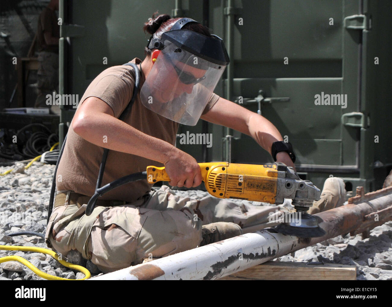 U.S. Navy Steel Worker 1st Class Jeannie Cooper, from Naval Mobile Construction Battalion 133, grinds rust and paint from a fla Stock Photo
