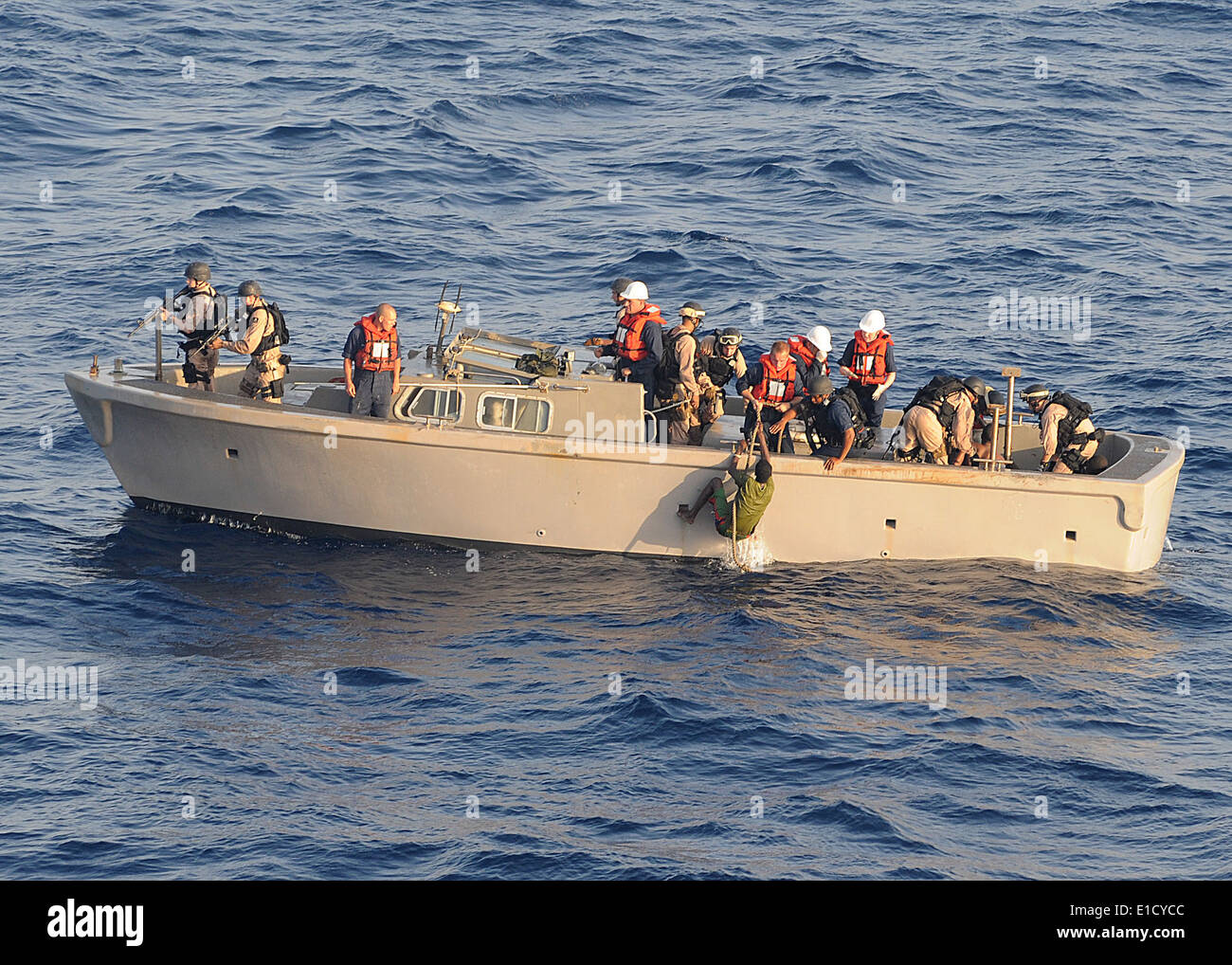 Members of a visit, board, search and seizure team pull a suspected pirate from the water in the Gulf of Aden April 10, 2010, p Stock Photo