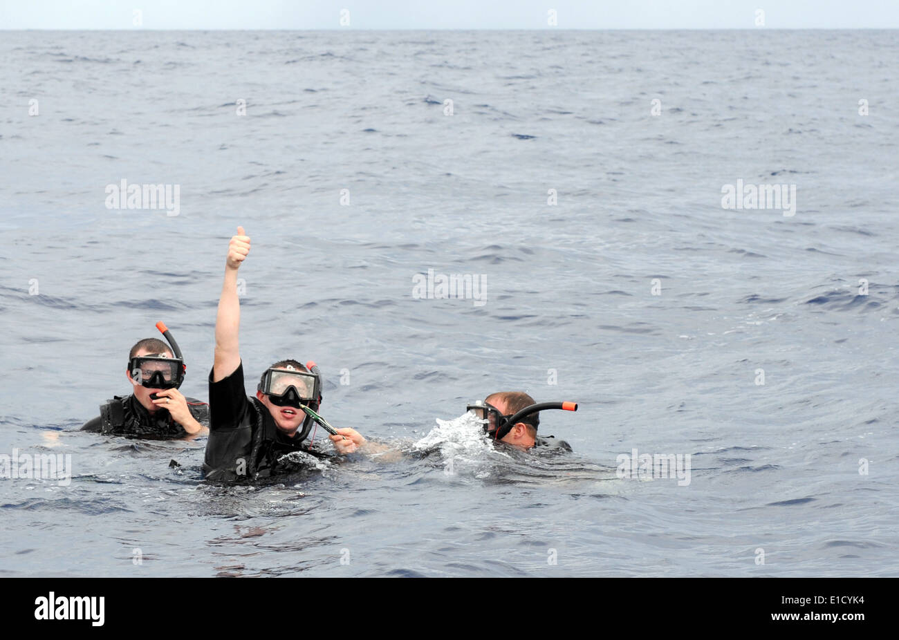U.S. Navy search and rescue (SAR) swimmers signal to a boat captain ...