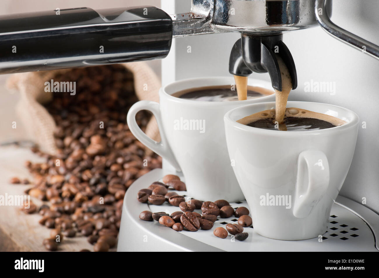 https://c8.alamy.com/comp/E1D0WE/coffee-machine-makes-two-coffee-with-coffee-beans-on-background-E1D0WE.jpg