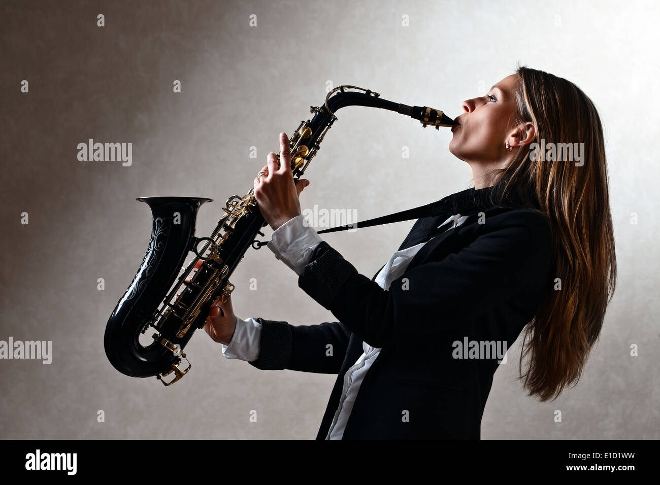 The young beauty with long hair plays a saxophone Stock Photo Alamy