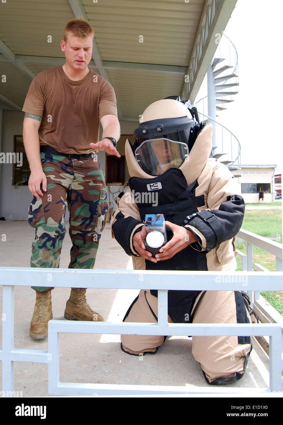 U.S. Navy Explosive Ordnance Disposal (EOD) Technician 2nd Class Brent Lawson, left, observes a Royal Cambodian Armed Forces EO Stock Photo