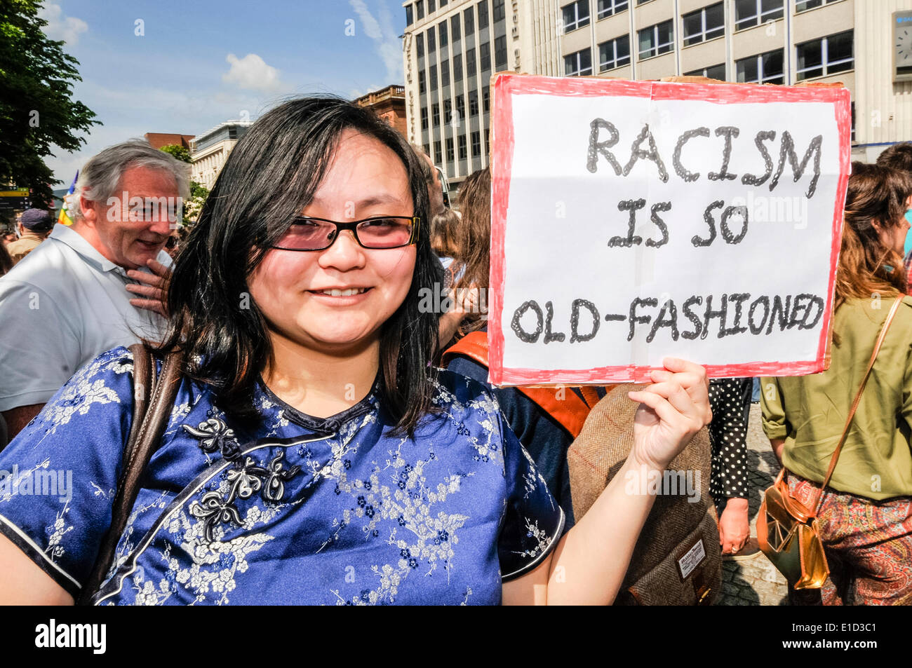Belfast, Northern Ireland. 31 May 2014 - A woman holds a sign saying 'Racism is so old-fashioned'. Thousands of people turn out for an anti-racism rally held in support of Anna Lo MLA.  Ms Lo had threatened to leave Northern Ireland because of the amount of racist attacks. Credit:  Stephen Barnes/Alamy Live News Stock Photo