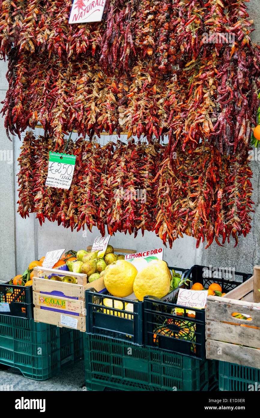 Strings of dried chillies, lemons and other fruit for sale in Amalfi, Italy Stock Photo
