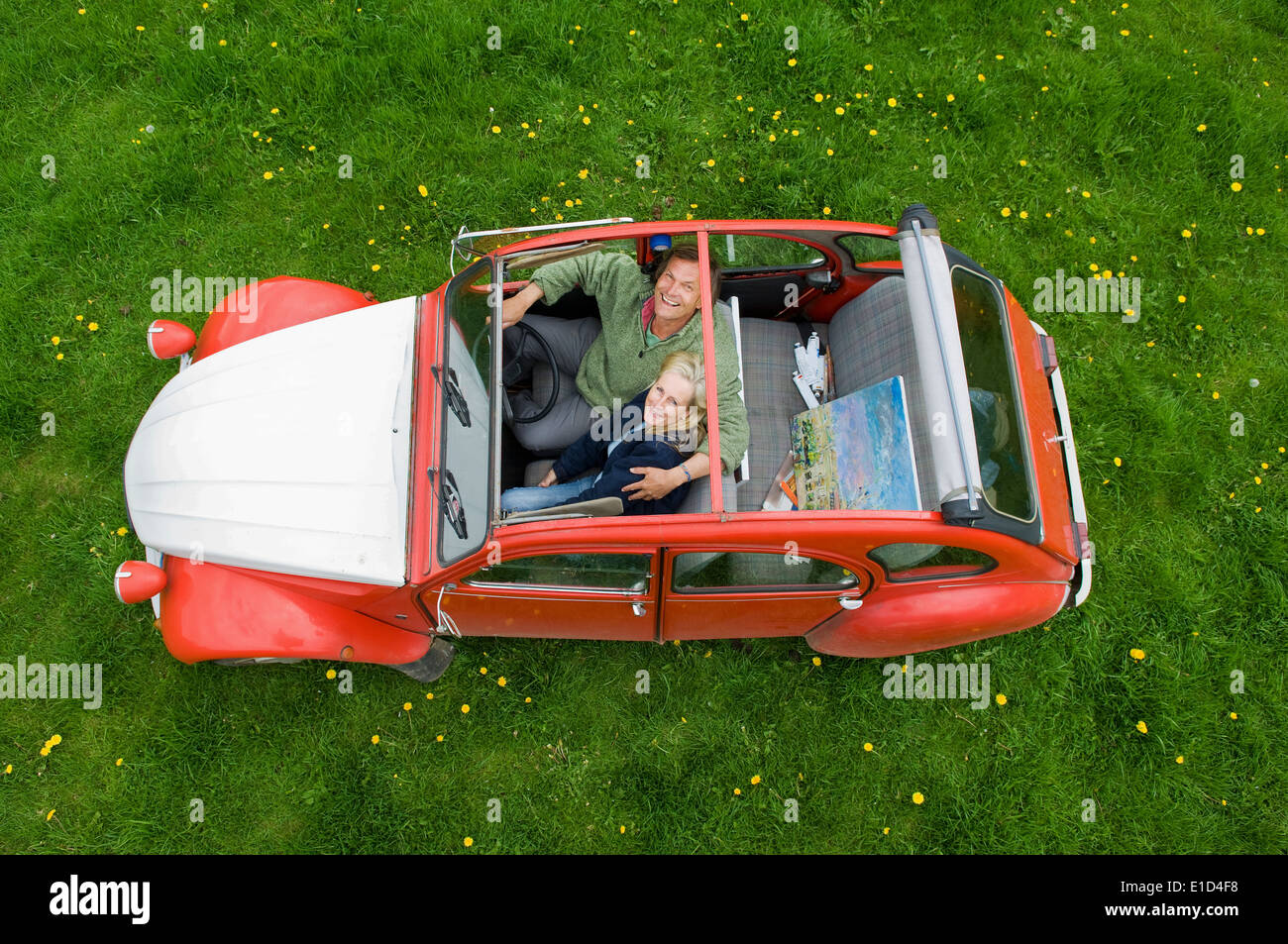 View from above of two people, a couple in a car with the roof open. Stock Photo