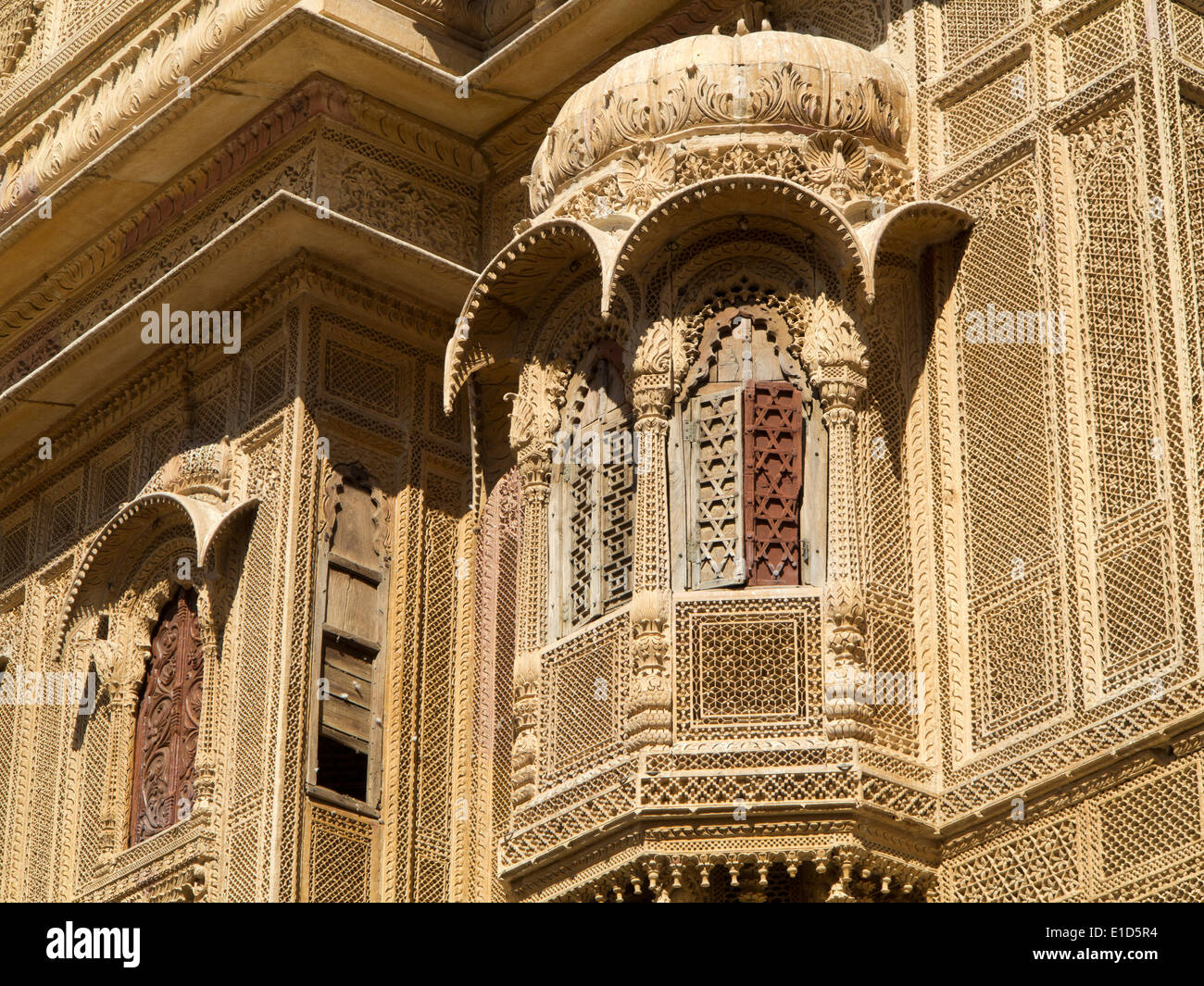 India, Rajasthan, Jaisalmer, Patwon Ki Haveli, carved sandstone projecting window balcony with wooden shutters Stock Photo