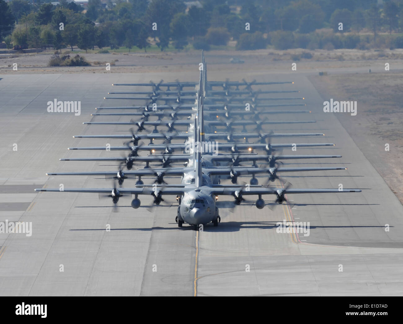 A row of C-130 Hercules aircraft taxi on Nellis Air Force Base, Nev., Nov. 18, 2009, during a Mobility Air Forces Exercise (MAF Stock Photo