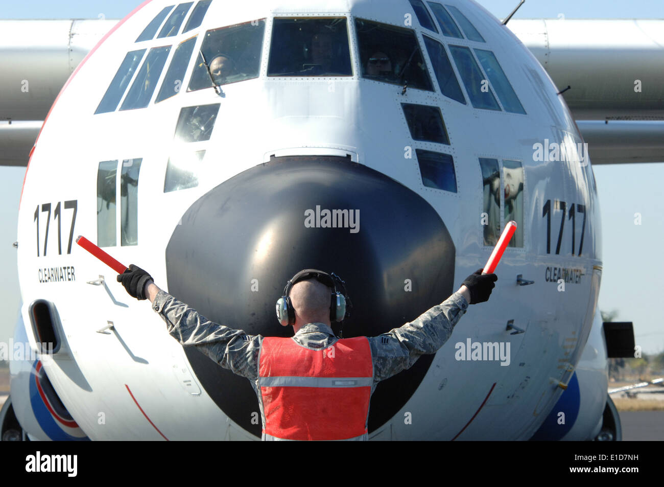 A U.S. Air Force crew chief directs a Coast Guard C-130 on the flight line at Homestead Air Reserve Base, Jan 20, 2010. The a Stock Photo