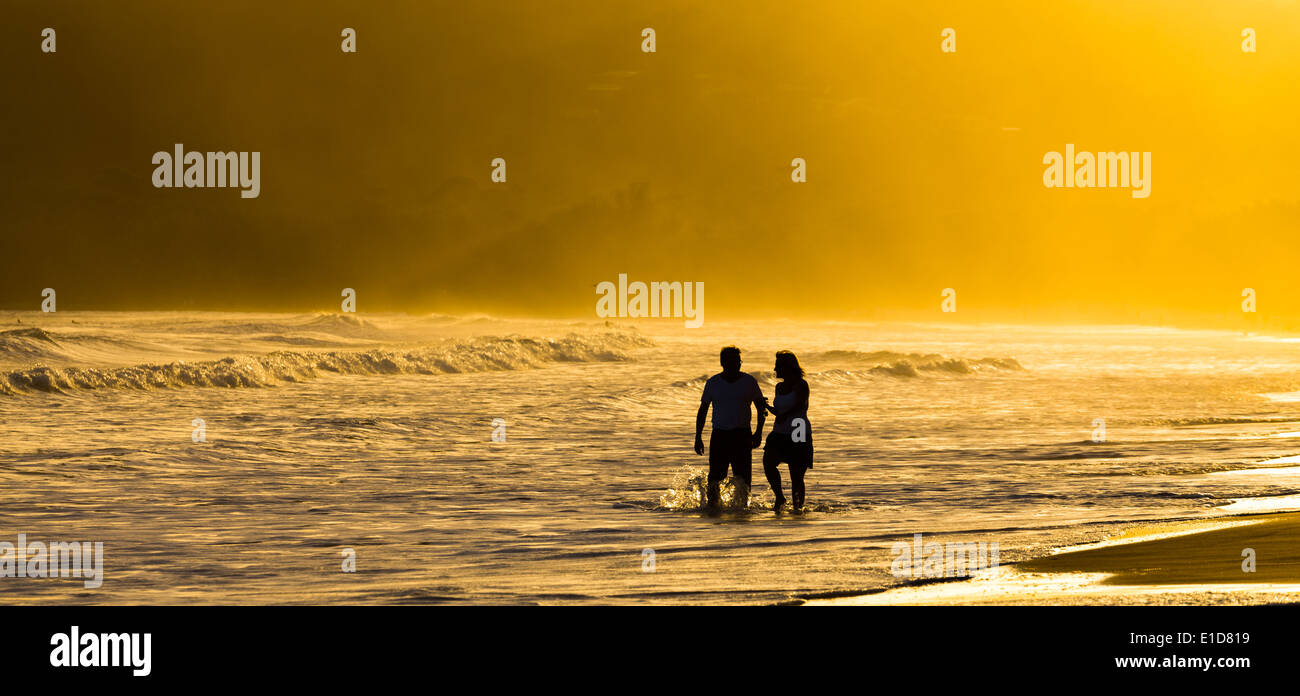 Silhouette of couple walking in water on Beach Stock Photo - Alamy