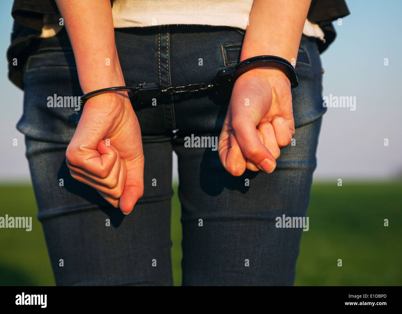 Woman with handcuffed hands outdoors Stock Photo